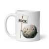 White ceramic mug that has an image of a grey rock that is holding a sign. The sign says 'I Rock.' The image is printed on both sides of the mug.