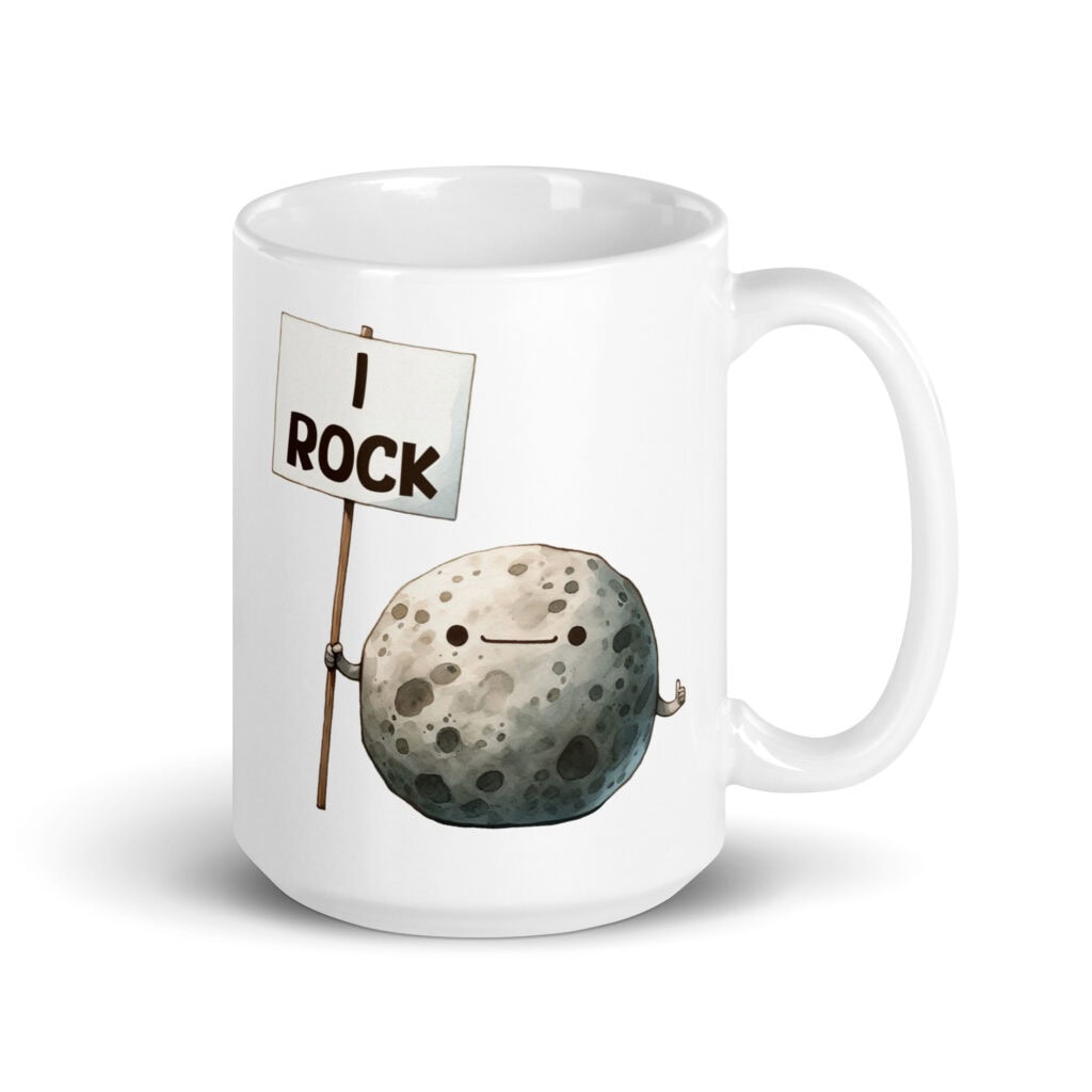 White ceramic mug that has an image of a grey rock that is holding a sign. The sign says 'I Rock.' The image is printed on both sides of the mug.