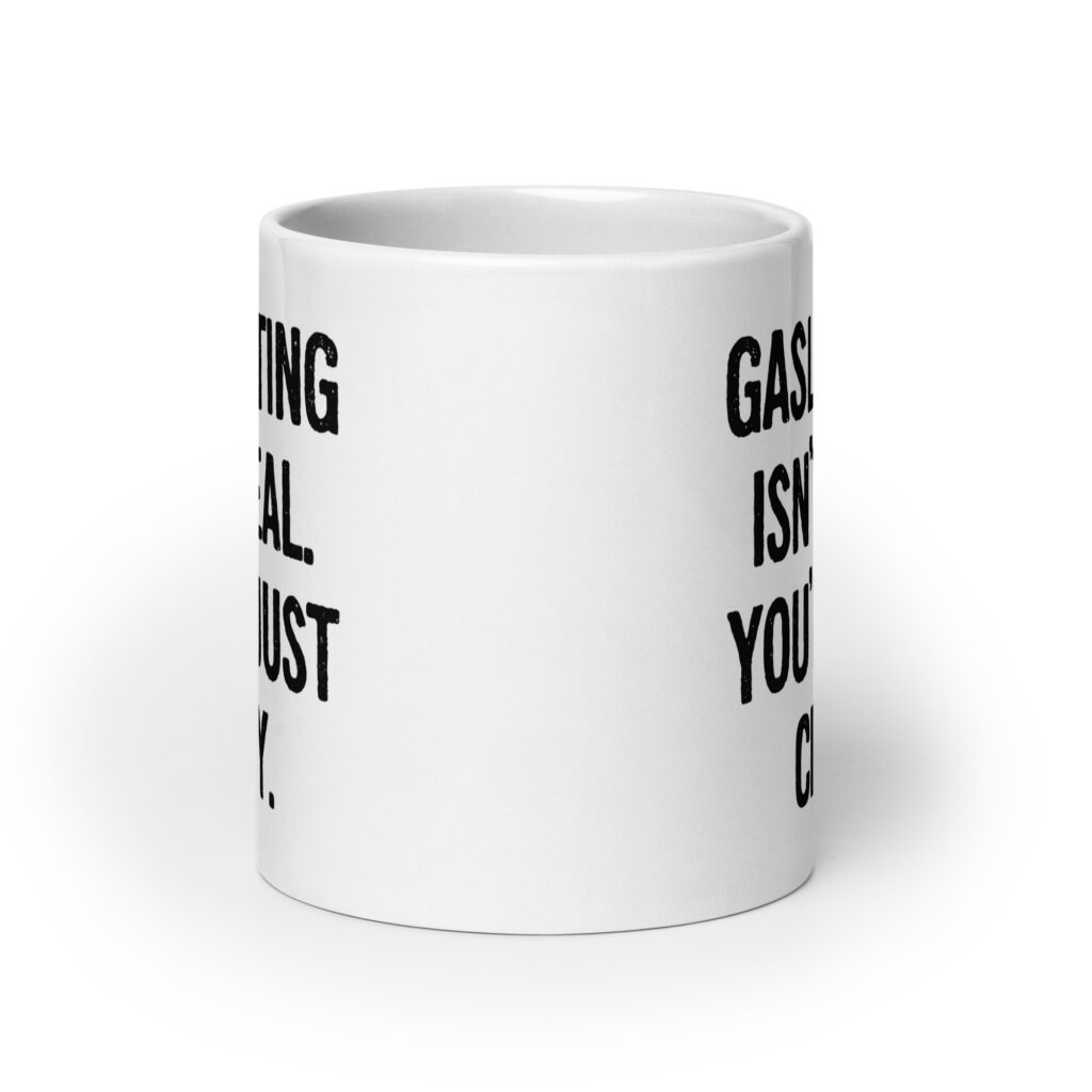 White ceramic mug with the text 'Gaslighting isn't real. You're just crazy.' printed on both sides in bold distressed font.