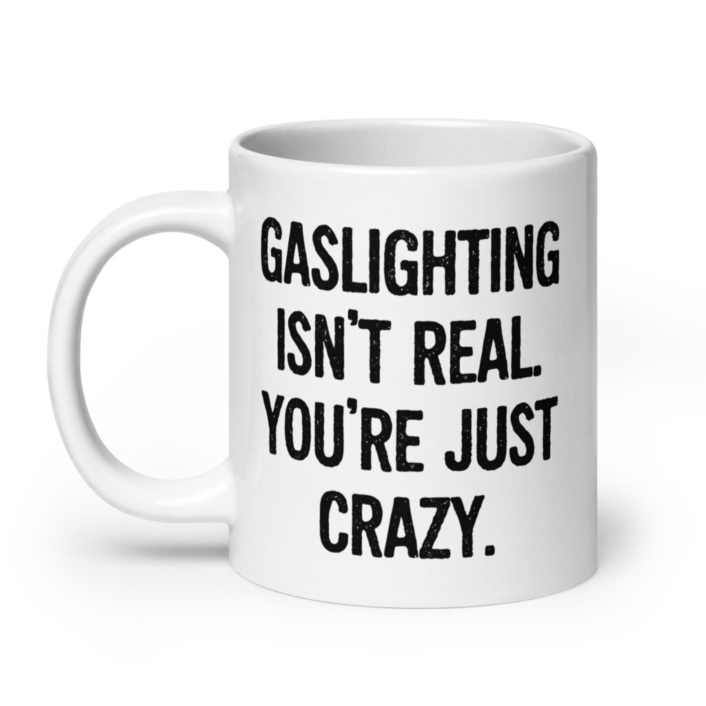 White ceramic mug with the text 'Gaslighting isn't real. You're just crazy.' printed on both sides in bold distressed font.