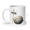 White ceramic mug that has an image of a grey rock that is holding a sign. The sign says 'I Rock.' The image is printed on both sides of the mug.