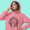 Woman wearing a coral pink color hoodie with a middle finger design on the front and the text 'I cunt be bothered to be less vulgar' printed on the front.