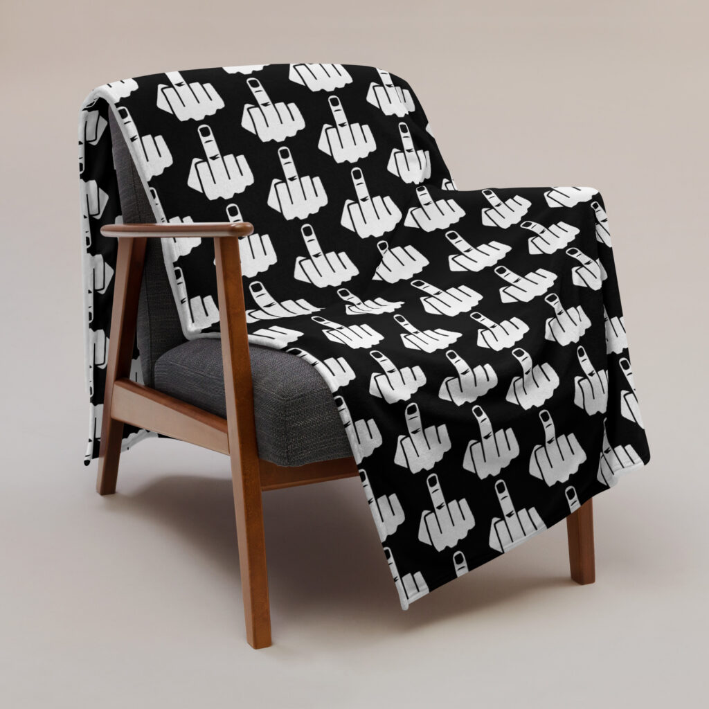 60 x 80 blanket with image of middle finger silhouette printed all over. The blanket is black and the graphic is white. Shown draped over a chair.