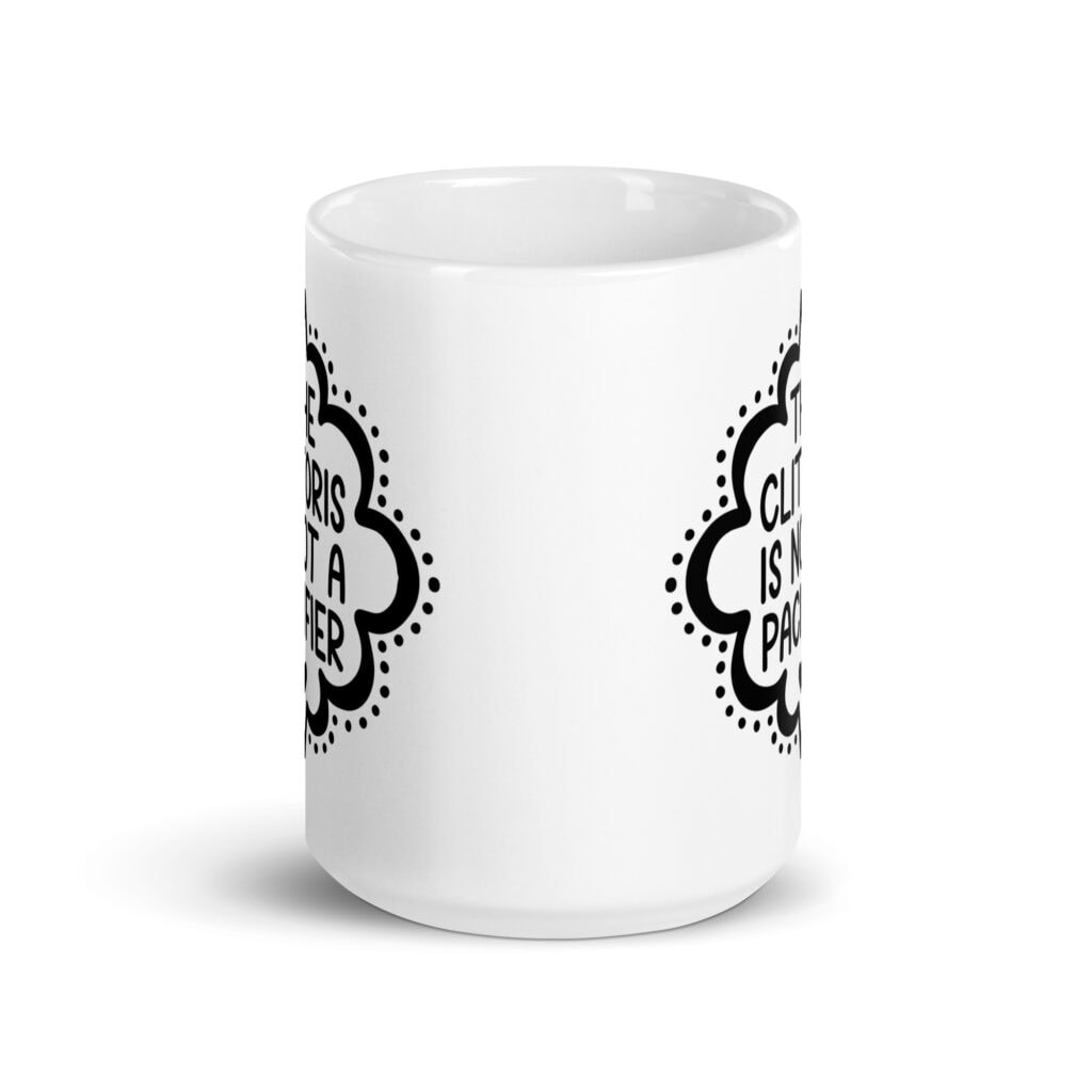 White ceramic mug with the text "The clitoris is not a pacifier" printed on both sides.