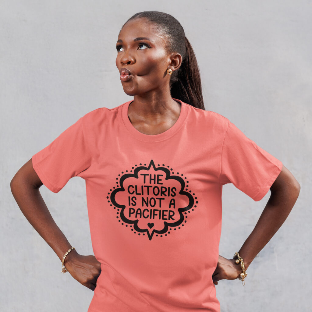 Woman wearing a coral color with the text "The clitoris is not a pacifier" printed on the front.