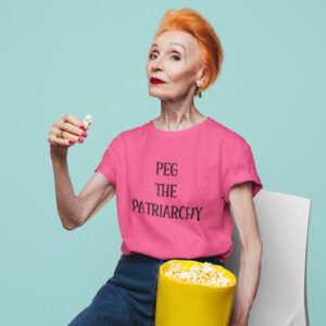 Woman wearing a heliconia pink t-shirt with the text 'PEG THE PATRIARCHY' printed on the front.