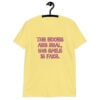 Cornsilk yellow t-shirt with the text 'The boobs are real, the smile is fake.' printed in pink on the front.