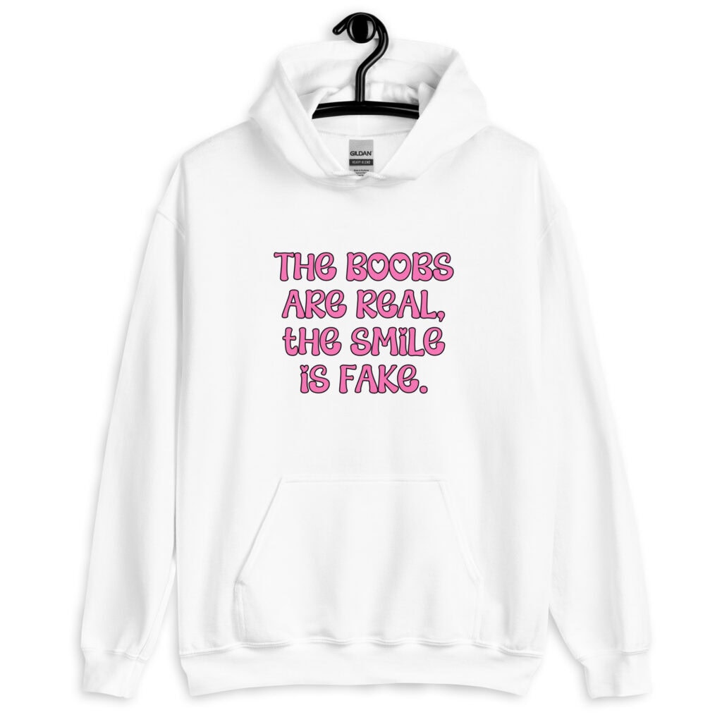 White hoodie sweatshirt with the text 'The boobs are real, the smile is fake.' printed in pink on the front.