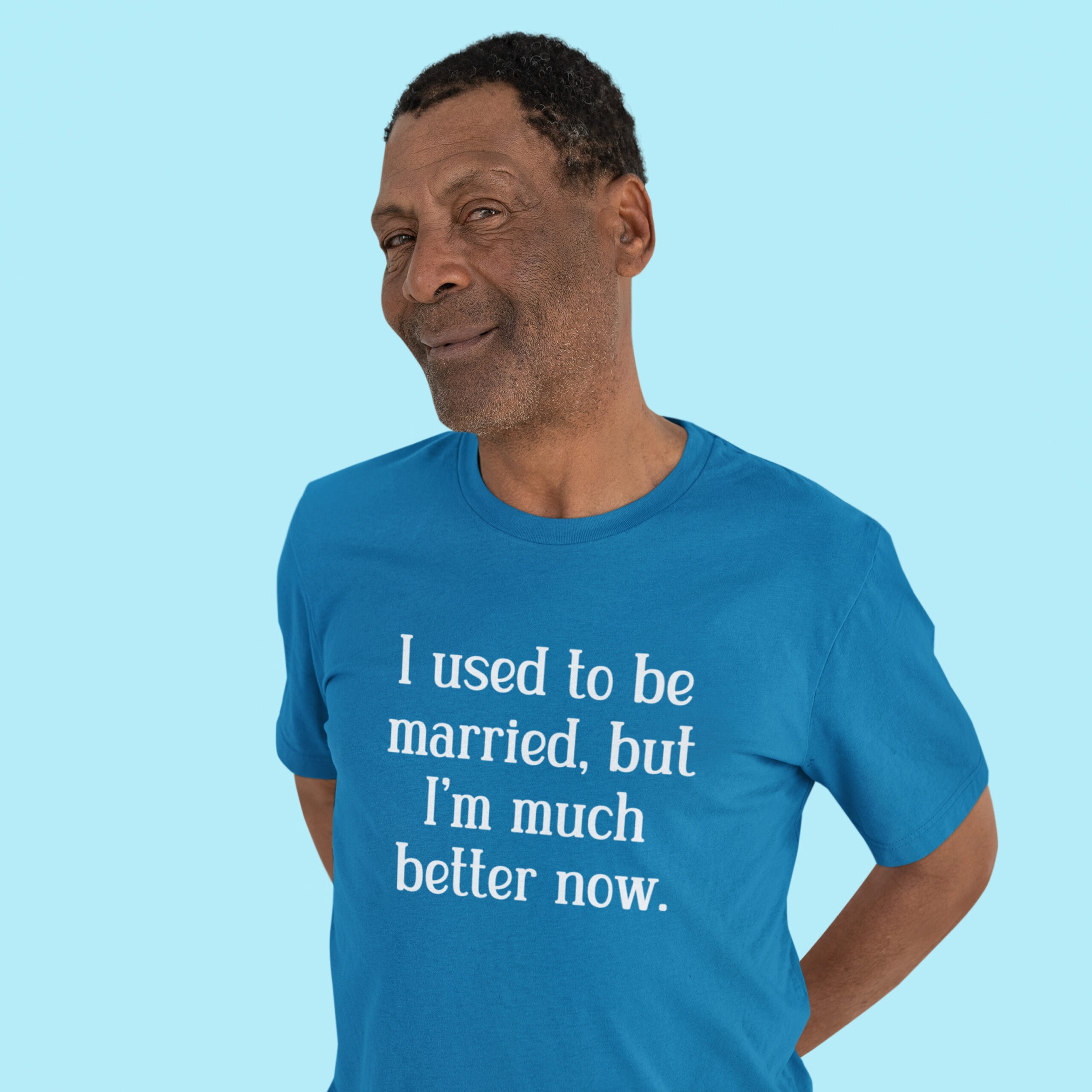 Man wearing a sapphire blue t-shirt with the text "I used to be married, but I'm much better now" printed on the front.