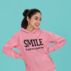 Woman wearing an azalea pink color hoodie sweatshirt with the text 'SMILE if you're a good boy' printed on the front.