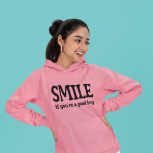 Woman wearing an azalea pink color hoodie sweatshirt with the text 'SMILE if you're a good boy' printed on the front.