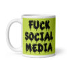 White and lime green ceramic coffee mug with the text 'Fuck social media' printed on the front in drippy graffiti style font on both sides of the mug.