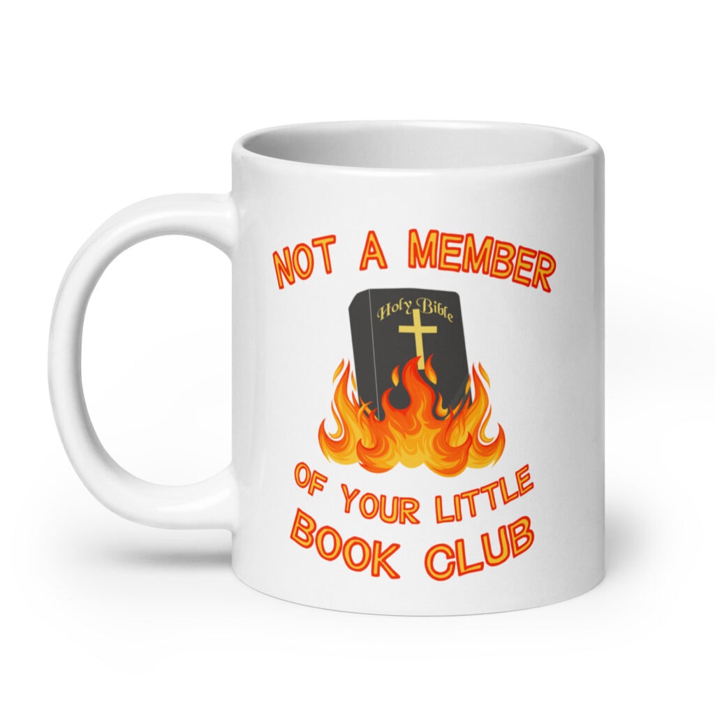 White ceramic mug with image of a burning bible and the text 'Not a member of your little book club' printed on both sides.