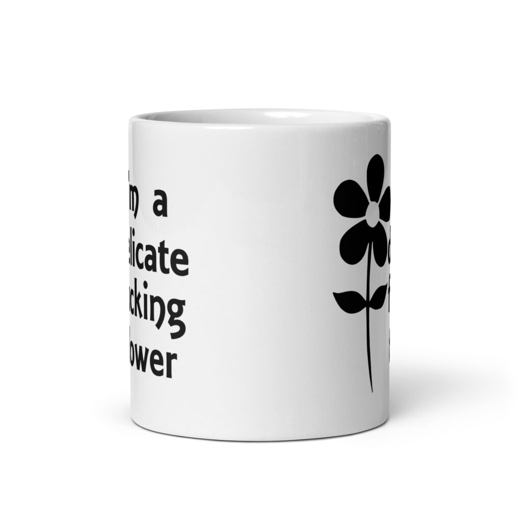 White ceramic mug with image of a flower and the text 'I'm a delicate fucking flower' printed on both sides.