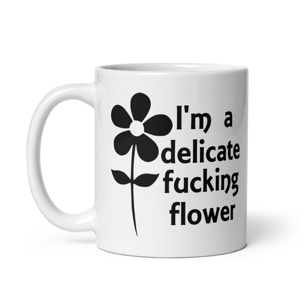 White ceramic mug with image of a flower and the text 'I'm a delicate fucking flower' printed on both sides.