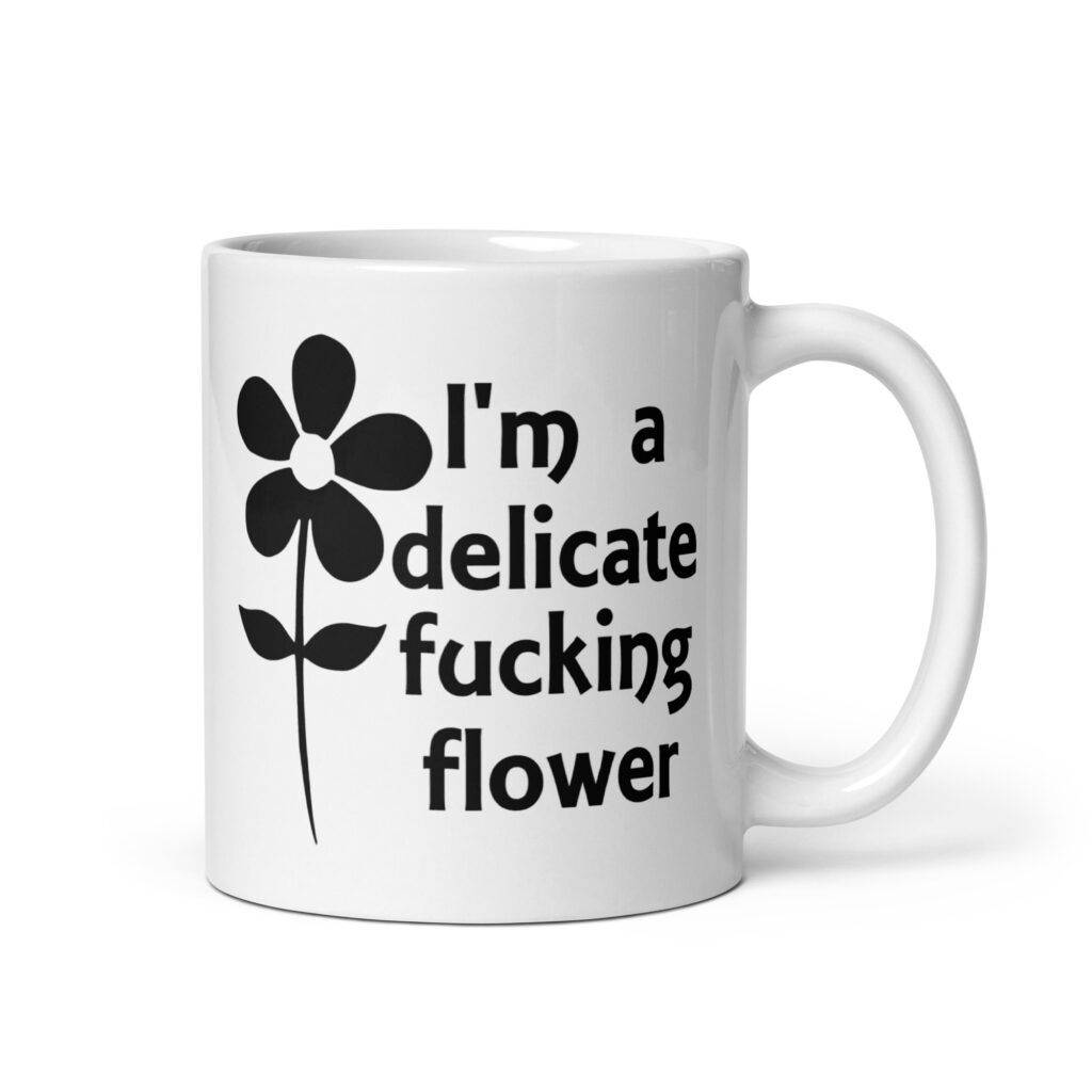 White ceramic mug with image of a flower and the text 'I'm a delicate fucking flower' printed on both sides.