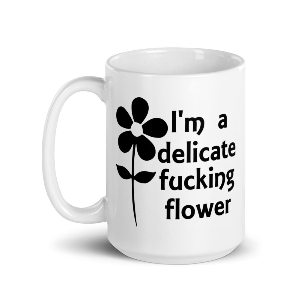 White ceramic mug with image of a flower and the text 'I'm a delicate fucking flower' printed on both sides.