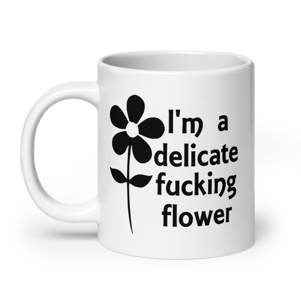White ceramic mug with image of a flower and the text 'I'm a delicate fucking flower' printed on both sides.