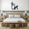 Rustic bedroom with wooden bed frame, neutral bedding, and black steel wall art mounted above the headboard.