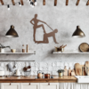 Rustic kitchen with concrete wall, wooden beams, and copper steel wall art mounted between two pendant lights.