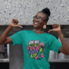 Woman wearing a jade color t-shirt with a retro frog and the phrase “On My Way to Fuck Shit Up” printed on the front.
