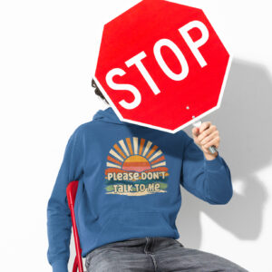 Man holding a stop sign while wearing an indigo blue hoodie sweatshirt with a retro sunrise design and the text 'Please don't talk to me' printed on the front.