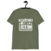 Military green t-shirt with bold white text reading ‘Adulting is a Scam’ in mixed block and distressed fonts. The design includes a smiley face, star, and flower icons, with a checkerboard stripe along the bottom.
