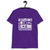 Purple t-shirt with bold white text reading ‘Adulting is a Scam’ in mixed block and distressed fonts. The design includes a smiley face, star, and flower icons, with a checkerboard stripe along the bottom.