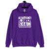 Purple hoodie sweatshirt with bold white text reading ‘Adulting is a Scam’ in mixed block and distressed fonts. The design includes a smiley face, star, and flower icons, with a checkerboard stripe along the bottom.