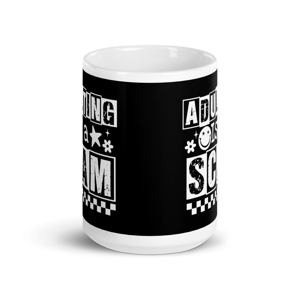 White ceramic mug featuring a black wraparound design with bold distressed white text reading ‘Adulting is a Scam.’ The text includes a smiley face, star, and flower icons, with a white checkerboard stripe along the bottom.