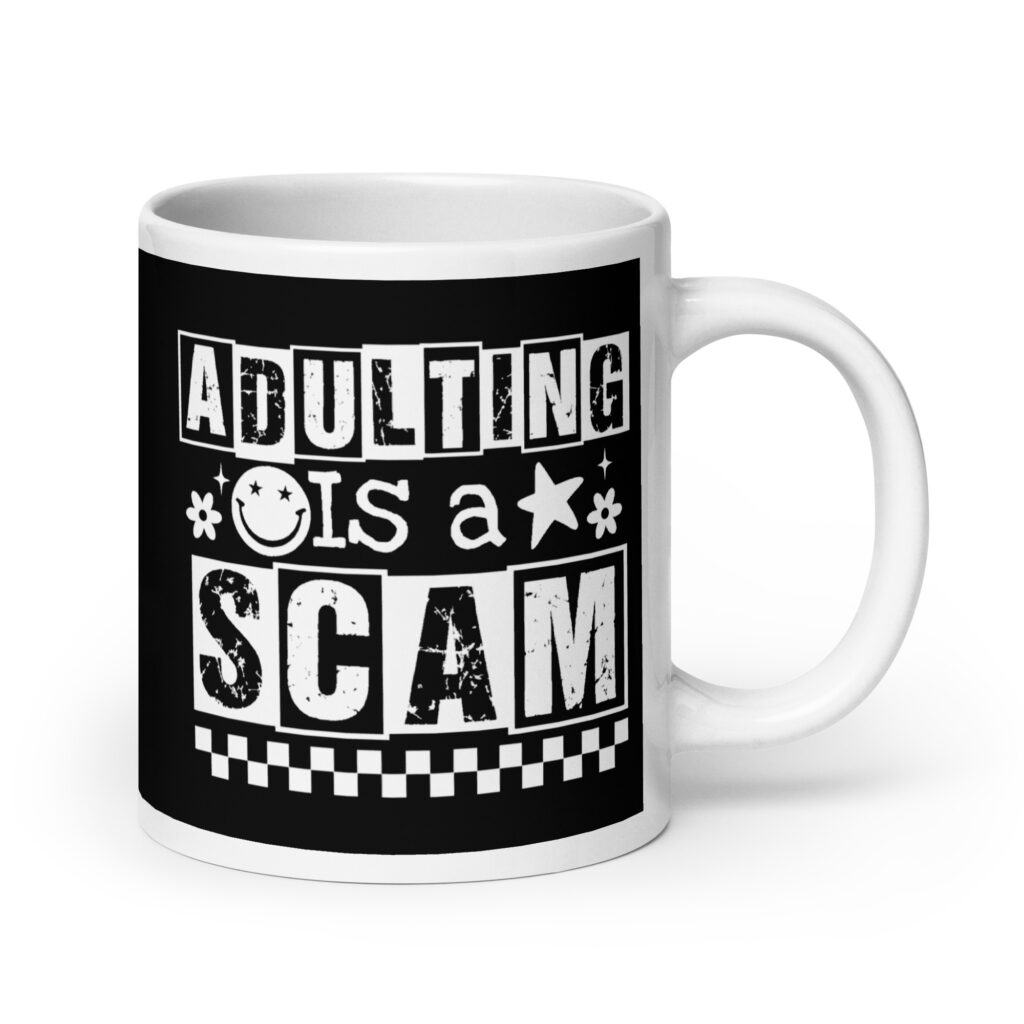White ceramic mug featuring a black wraparound design with bold distressed white text reading ‘Adulting is a Scam.’ The text includes a smiley face, star, and flower icons, with a white checkerboard stripe along the bottom.