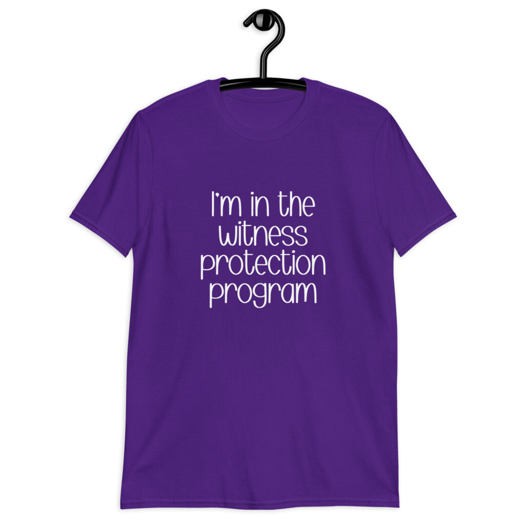 Purple t-shirt with the text 'I'm in the witness protection program' printed on the front.