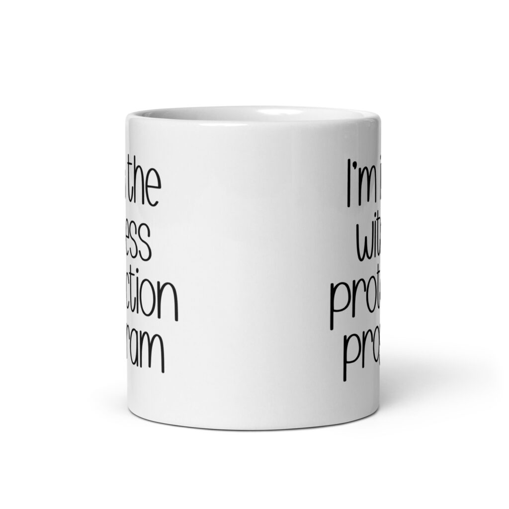White ceramic mug with the text 'I'm in the witness protection program' printed on both sides.