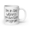 White ceramic mug with the text 'I'm in the witness protection program' printed on both sides.