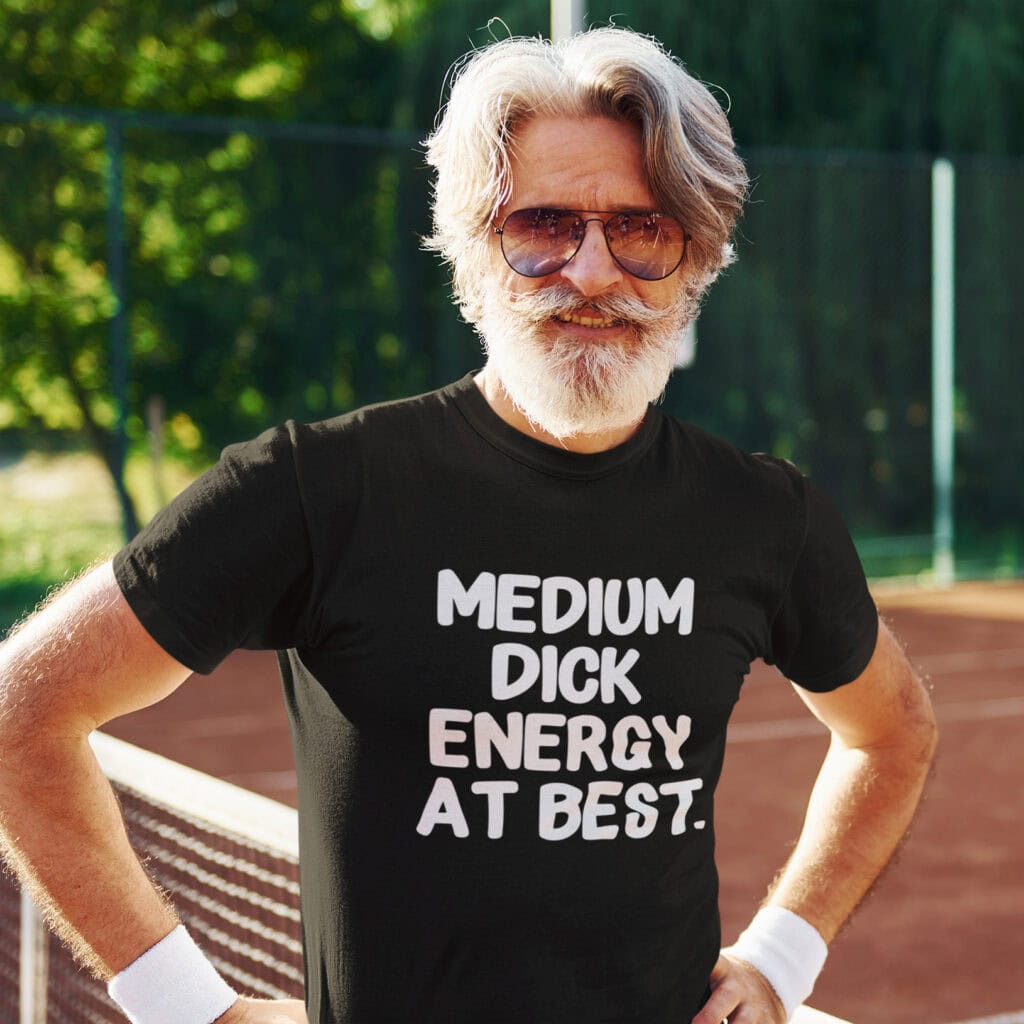 Man wearing a black t-shirt with the text 'MEDIUM DICK ENERGY AT BEST.' printed on the front.